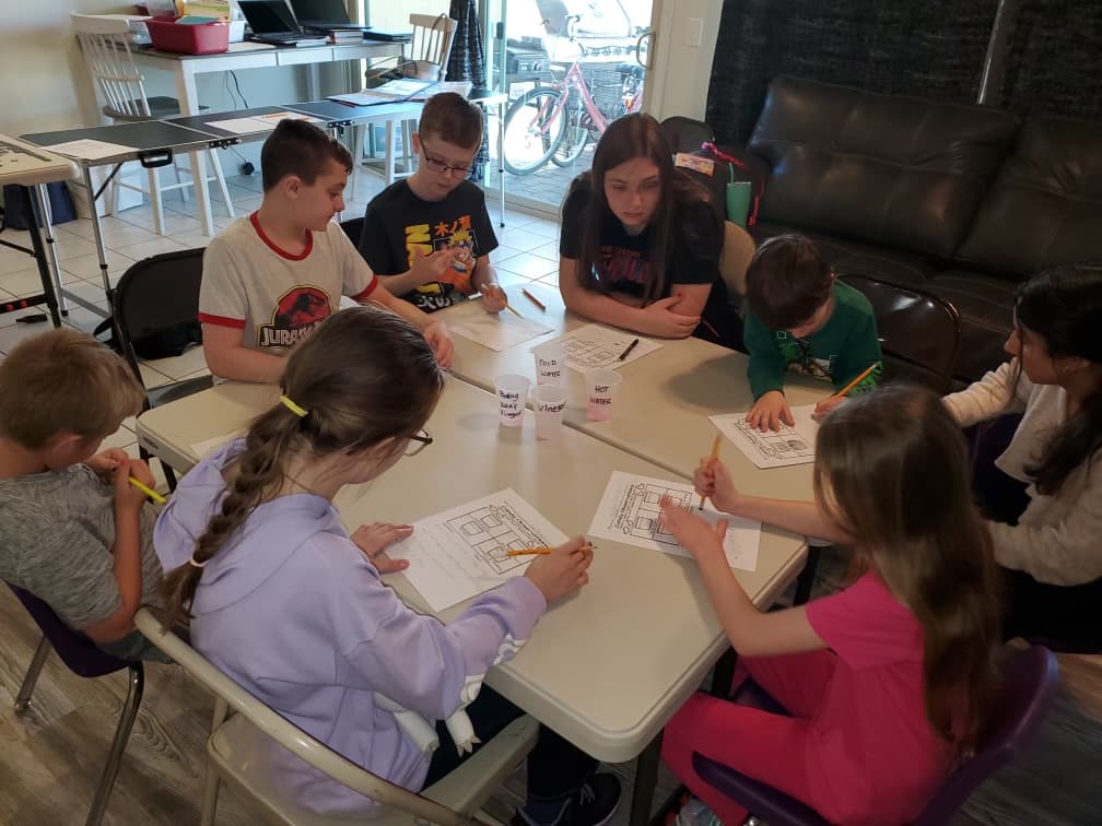 Students working together around a table at Community Schoolhouse.